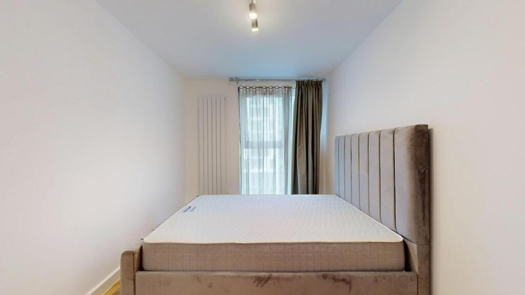 A modern double bedroom featuring a plush uphol...
