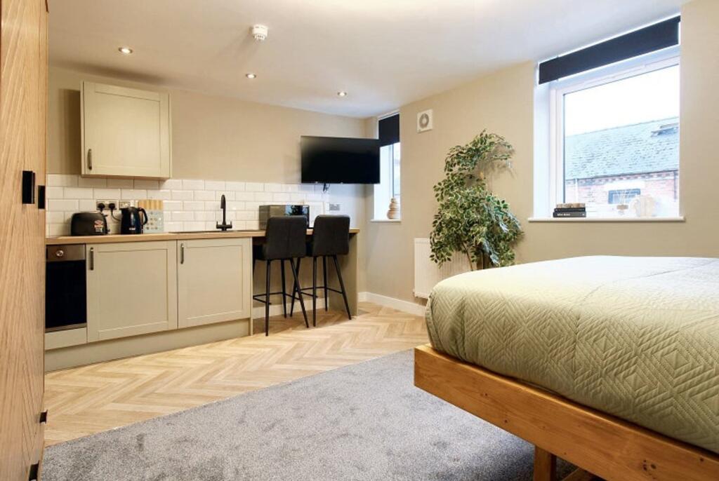 Spacious double bedroom featuring a cozy bed an...