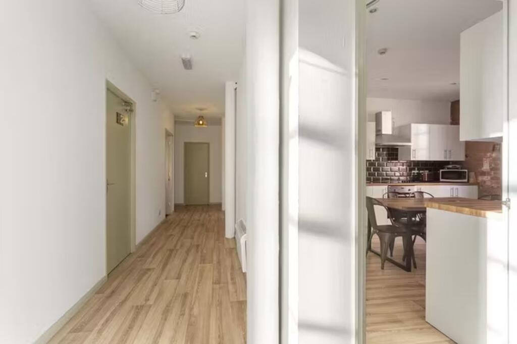 A bright and tidy hallway leading to a modern k...