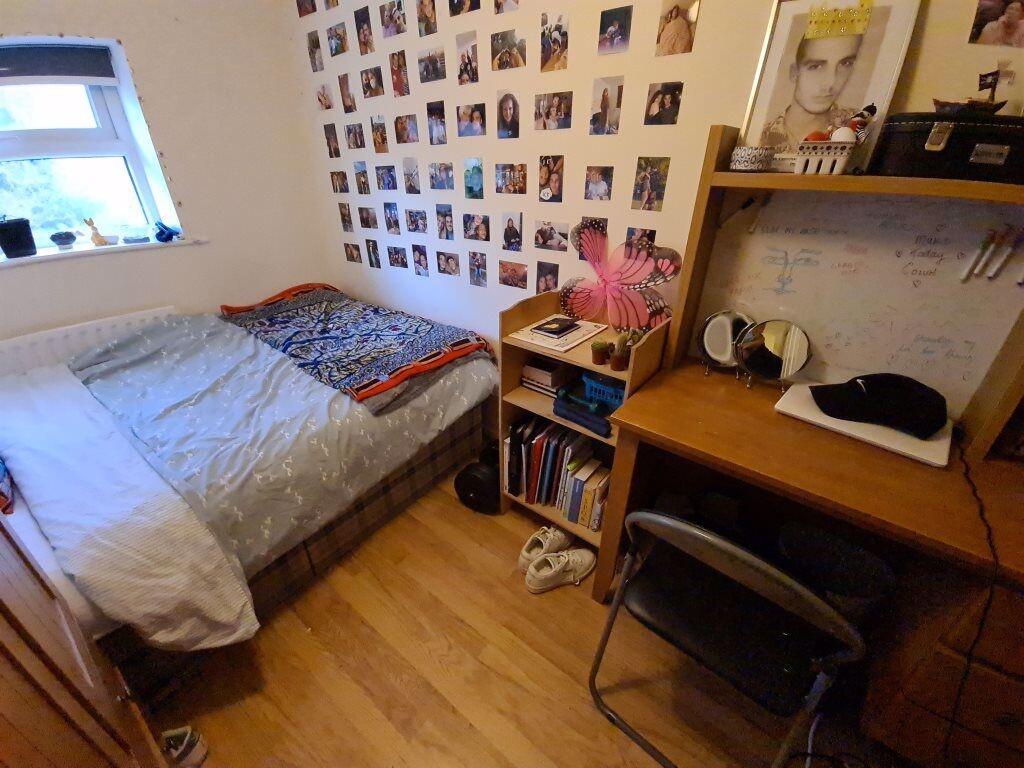 A cozy single bedroom featuring a neatly made b...