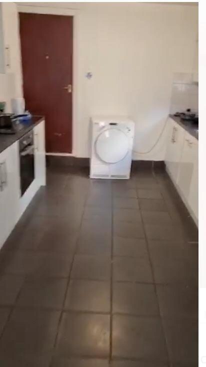 A tidy kitchen featuring modern white cabinetry...