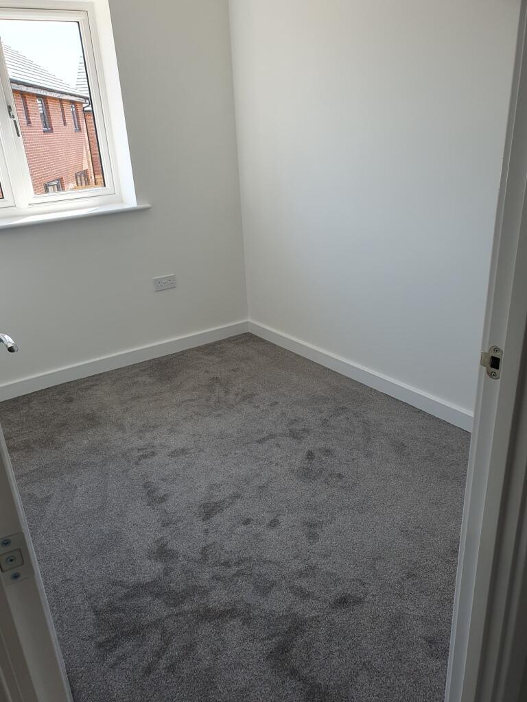 A cozy double bedroom featuring soft gray carpe...