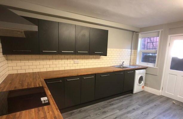 A modern, well-maintained kitchen featuring dar...