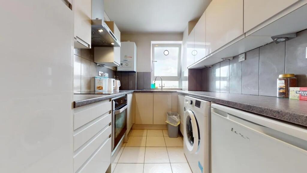 A clean and modern kitchen featuring white cabi...