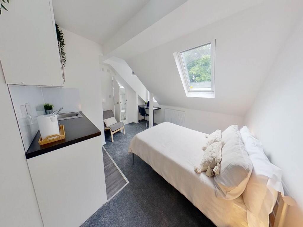 Bright and cozy single bedroom featuring a comf...