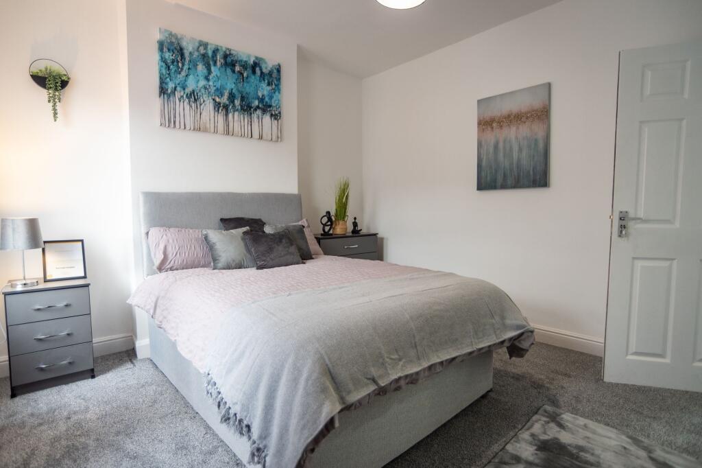 A cozy and neatly arranged double bedroom with ...
