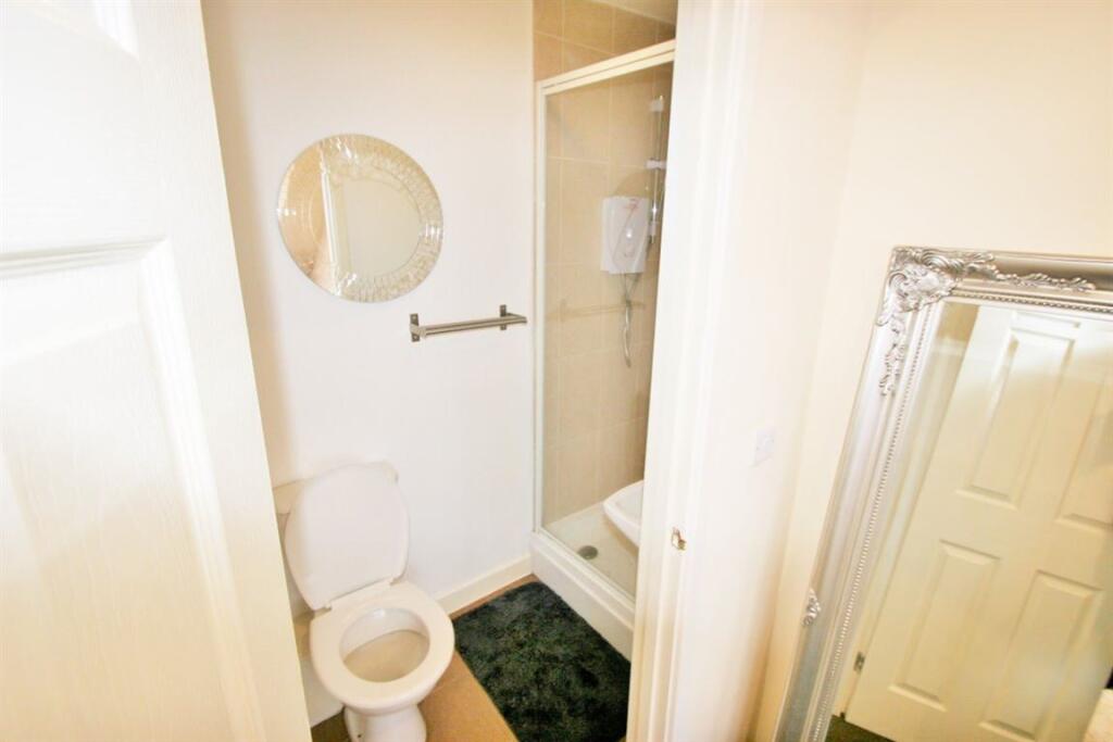 A clean and bright bathroom featuring a toilet,...