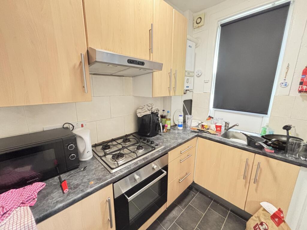 A compact kitchen area with modern fitted units...