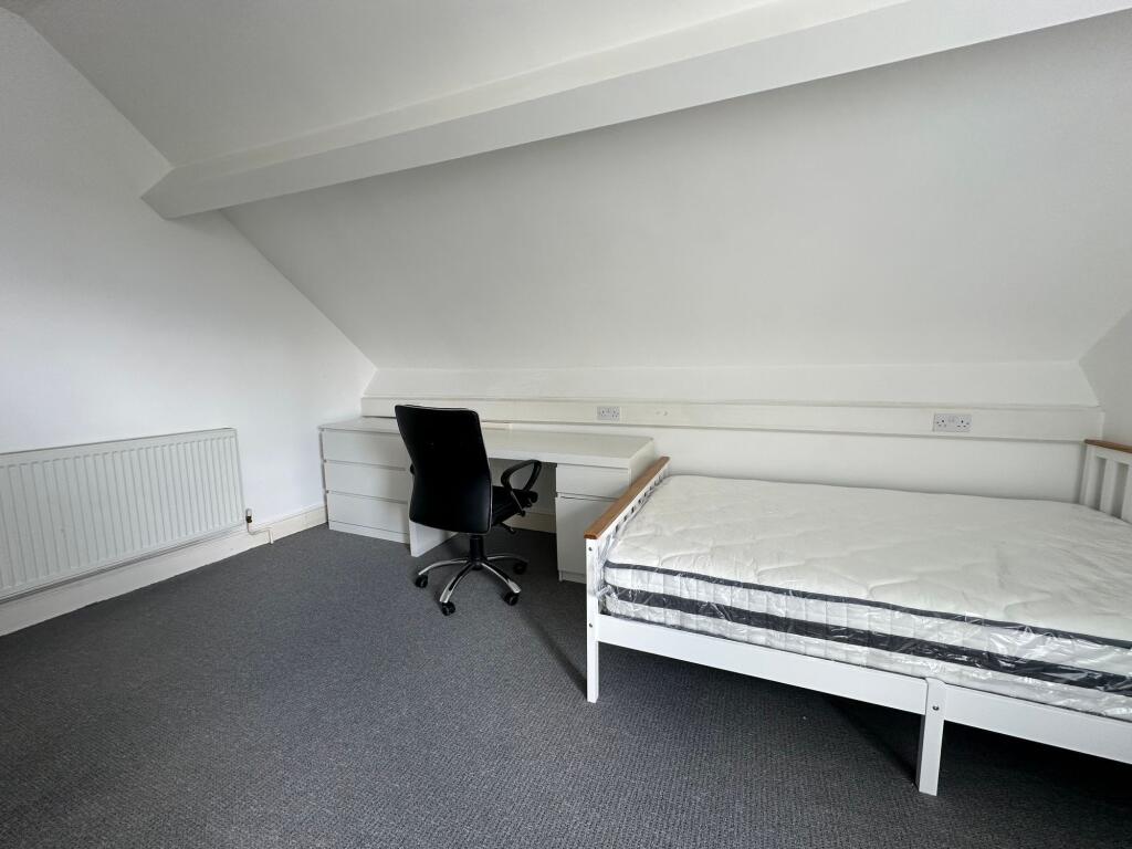 A clean and simple single bedroom featuring a w...