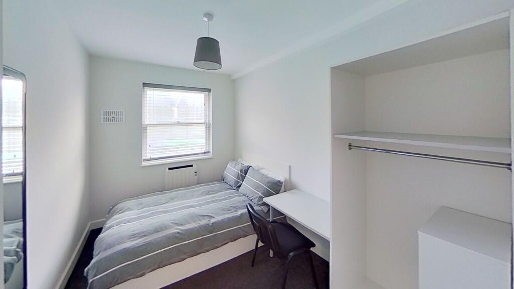 A neat and bright single bedroom featuring a co...