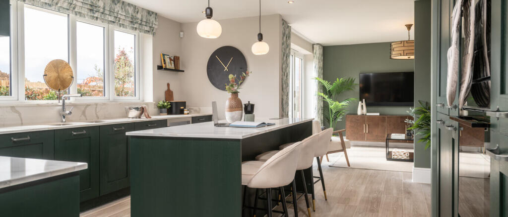 Modern open-plan kitchen and living area with green and white decor, large windows, and contemporary