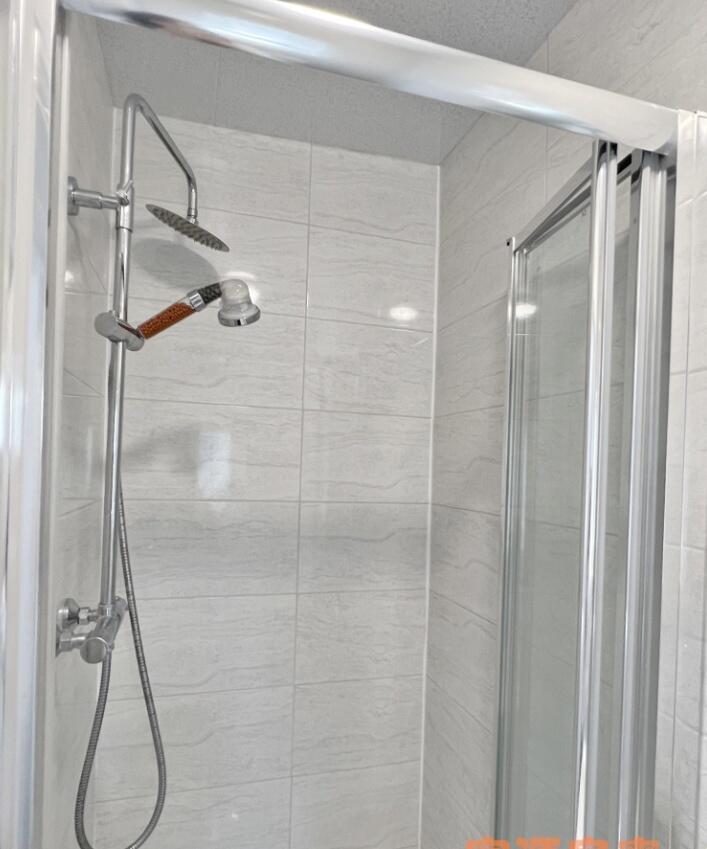 A modern bathroom shower area featuring a dual ...