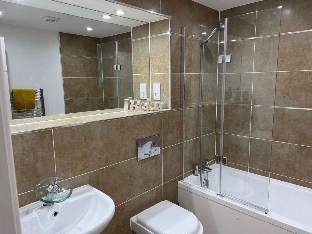 A modern and spacious bathroom featuring a rela...