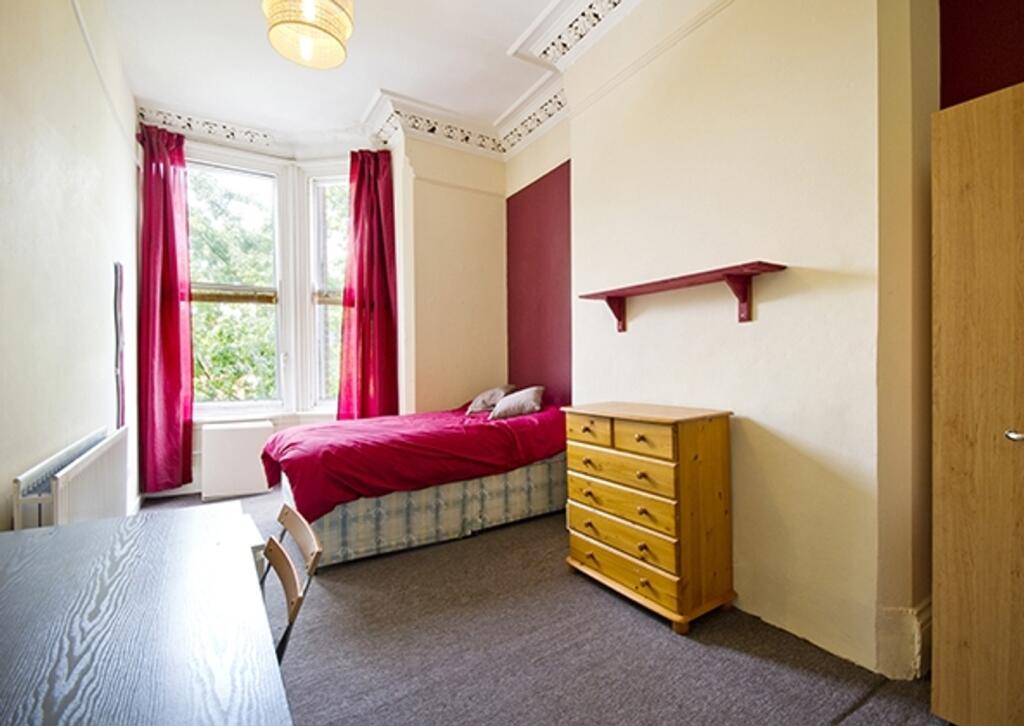 A bright and inviting double bedroom with a com...