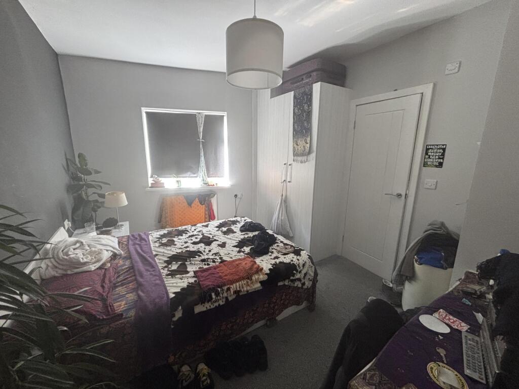 A cozy bedroom featuring a double bed with colo...