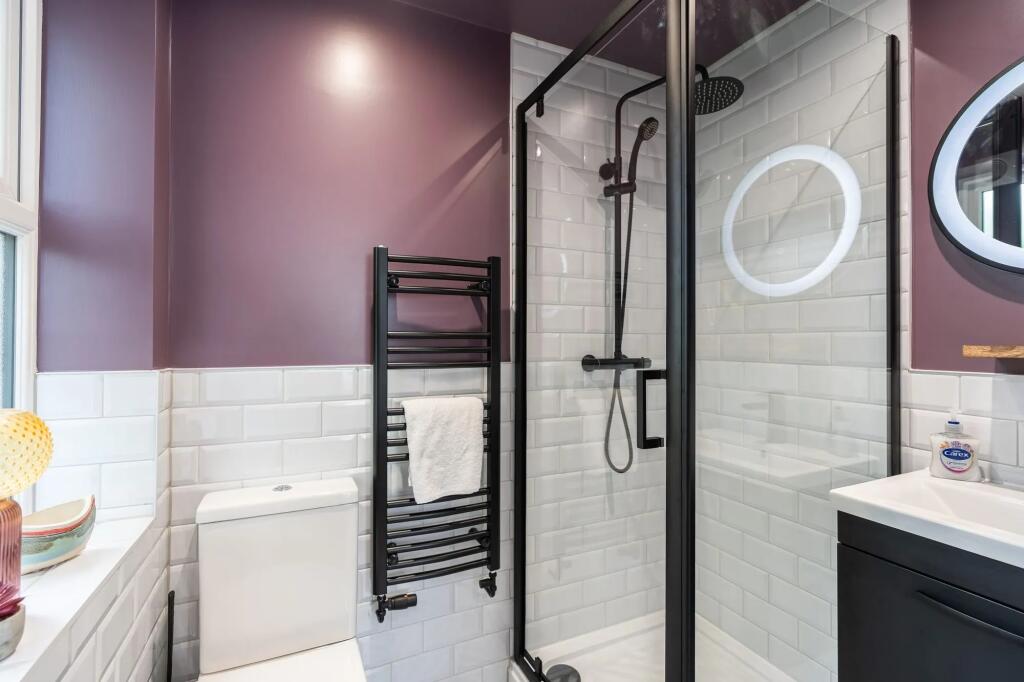 Modern bathroom with white subway tiles, a glas...