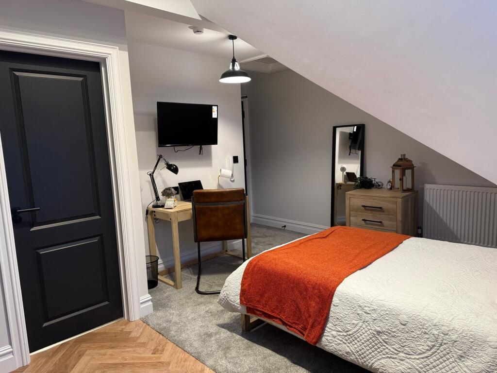 A cozy double bedroom featuring a neatly made b...