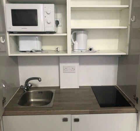 Compact and tidy kitchenette featuring essentia...