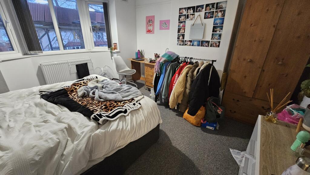 A cozy double bedroom with a comfortable bed, a...