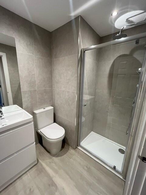 Modern bathroom featuring a spacious shower enc...