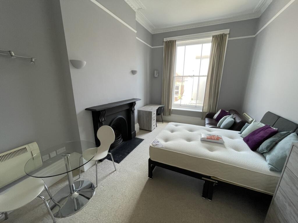 A spacious master bedroom featuring a large win...