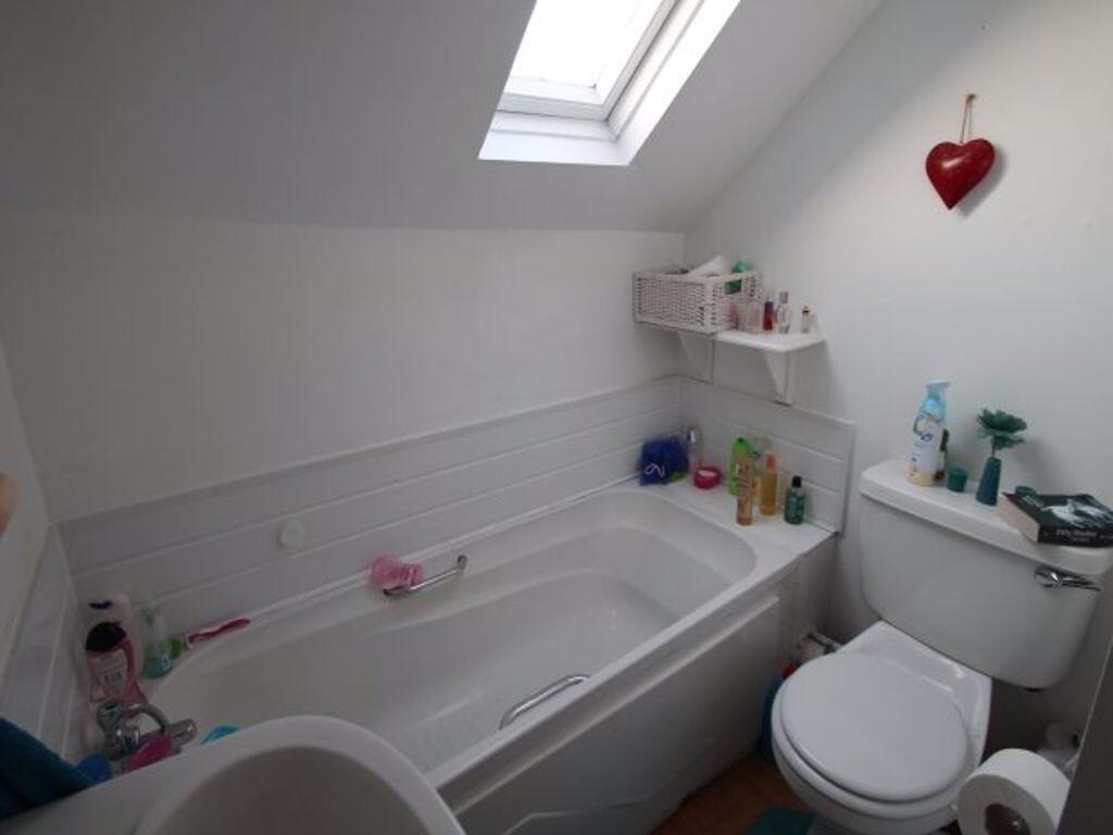 A well-maintained bathroom featuring a bathtub ...