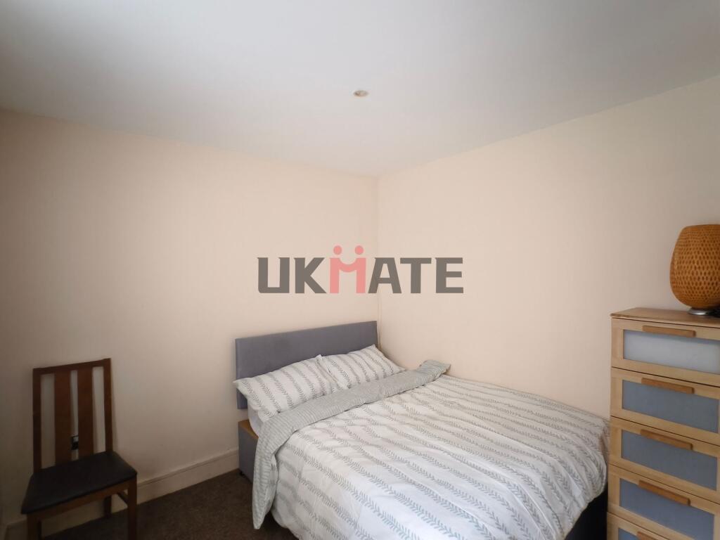 A cozy bedroom featuring a comfortable double b...