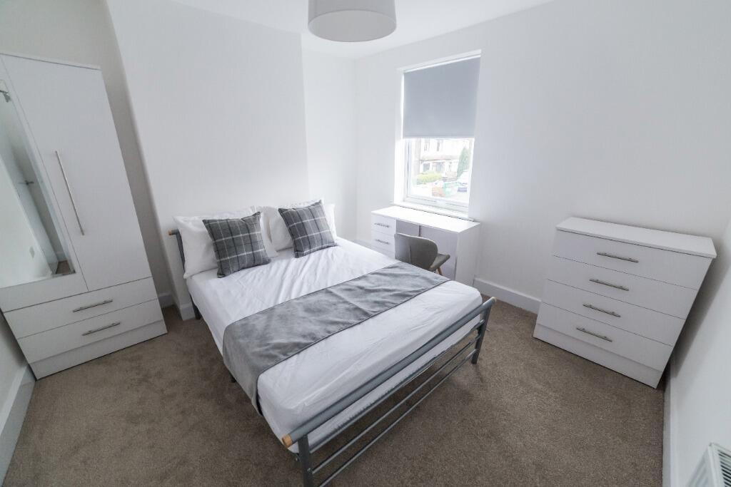 This inviting double bedroom features a comfort...