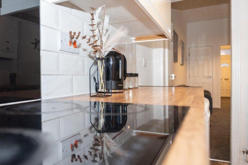 A sleek, modern kitchen featuring a glossy blac...