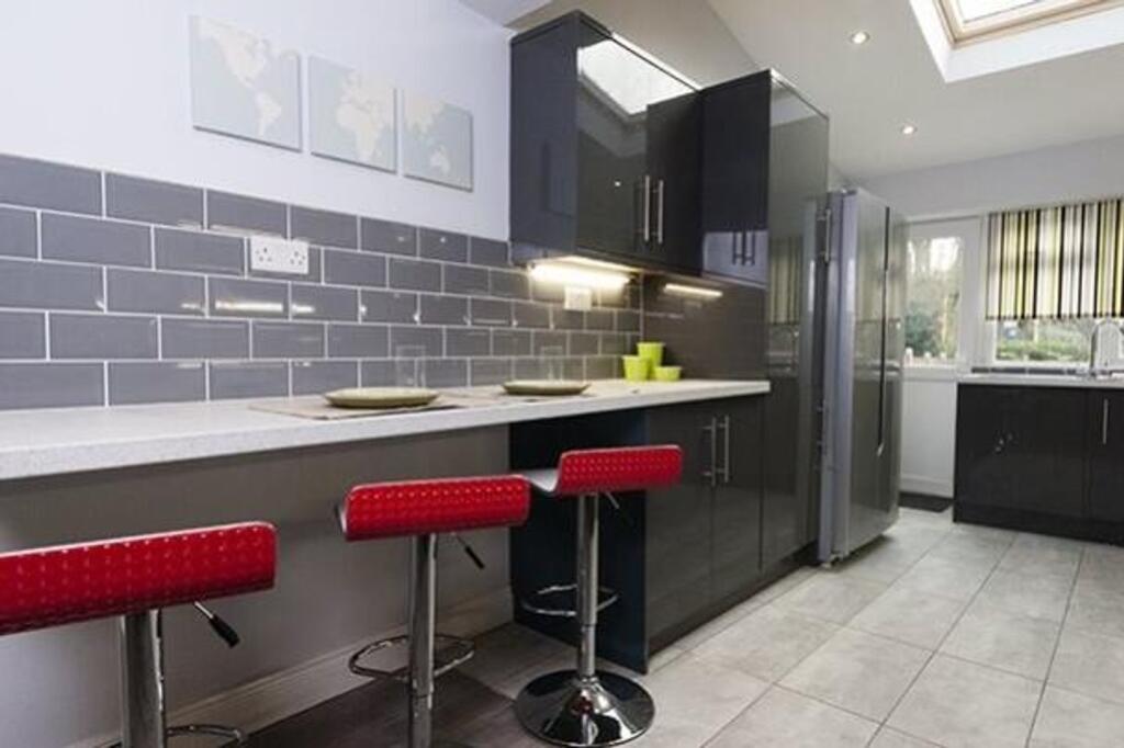 A modern and stylish kitchenette with sleek cab...