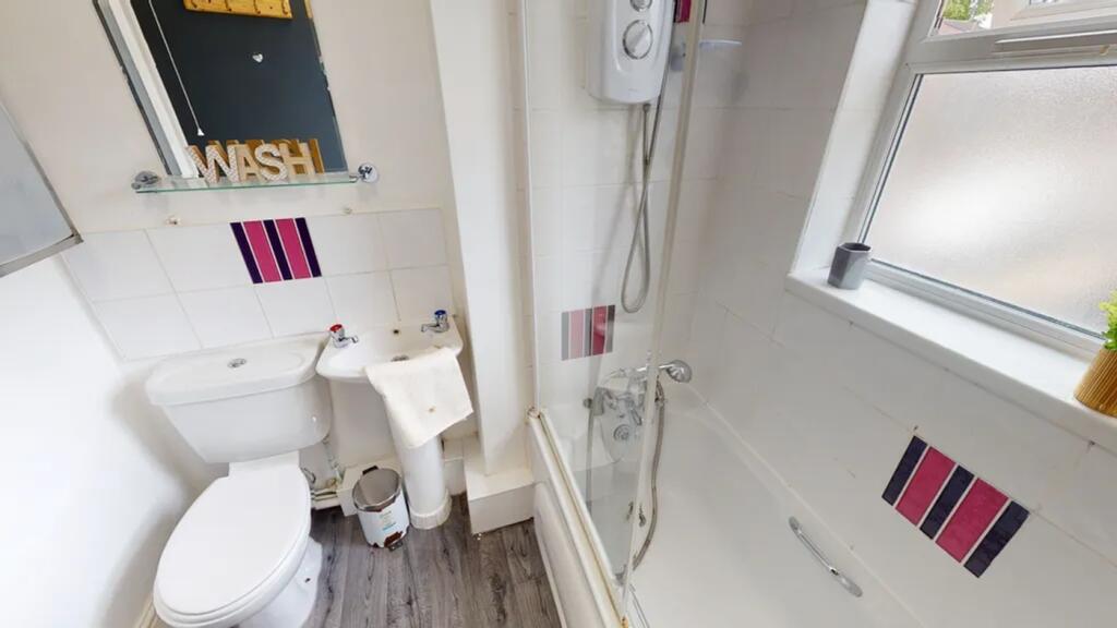 A tidy and modern bathroom featuring a shower a...