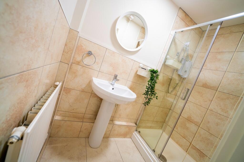 Comfortable bathroom featuring a sink, a shower...