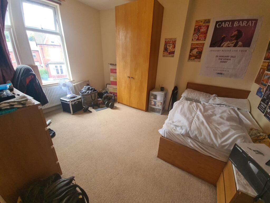 A cozy single bedroom featuring a large window ...