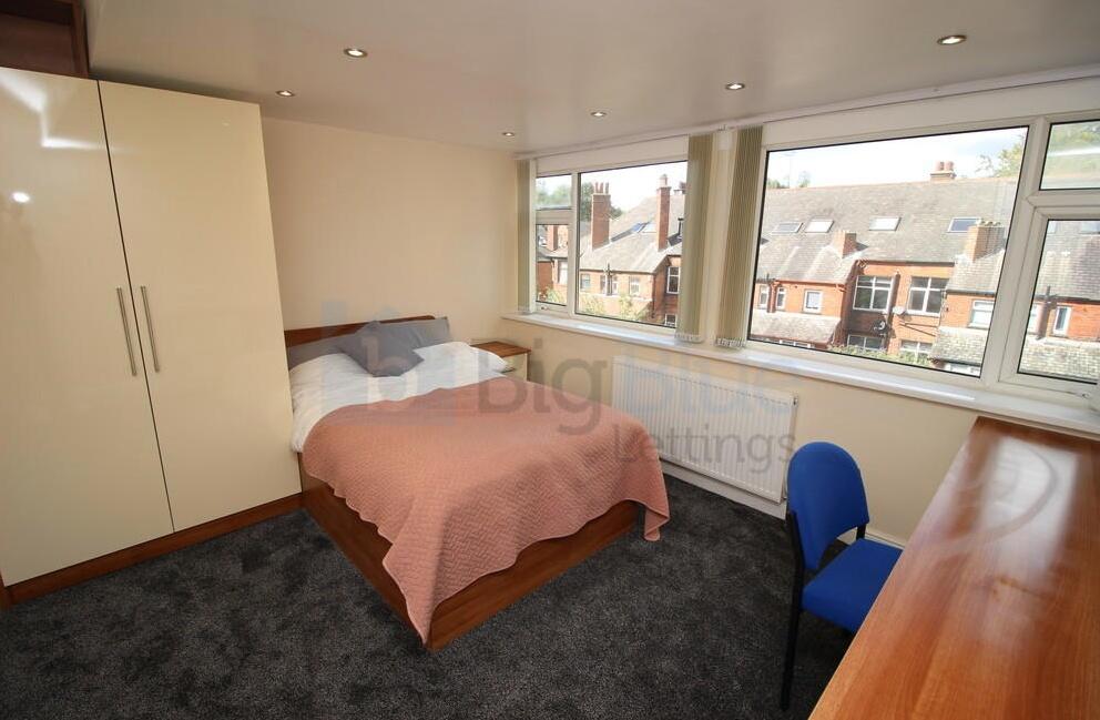 Bright double bedroom featuring a comfortable d...