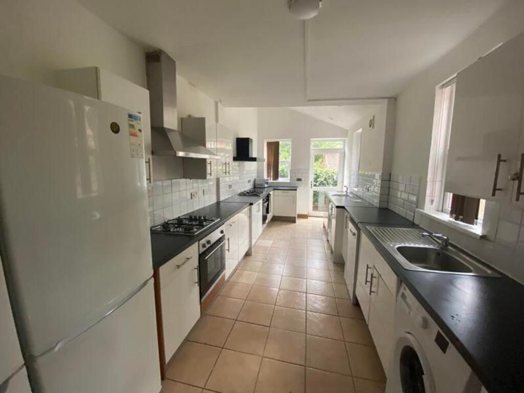 A spacious and bright kitchen equipped with mod...
