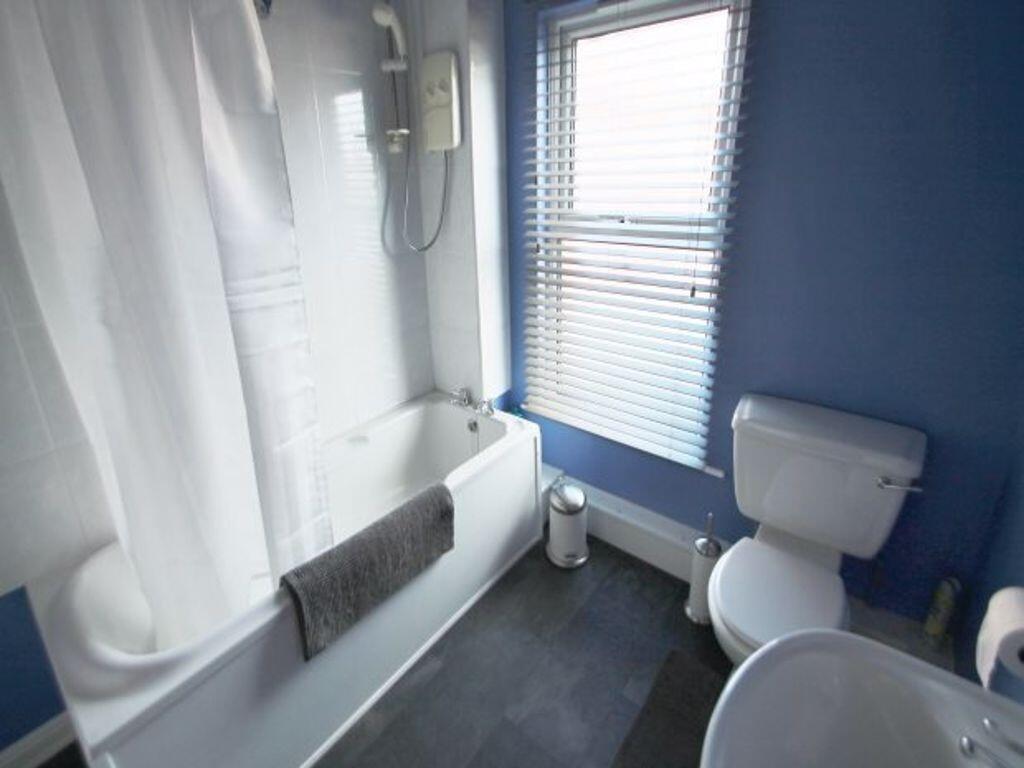 A neat and tidy bathroom featuring a white bath...