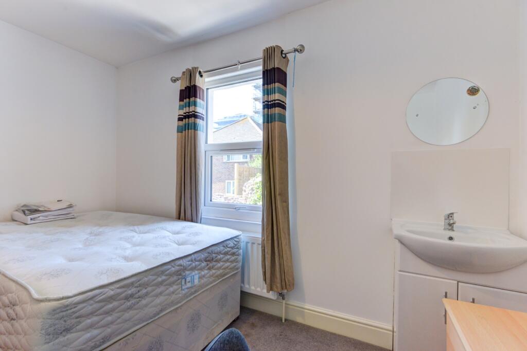 A simple and tidy bedroom featuring a single be...