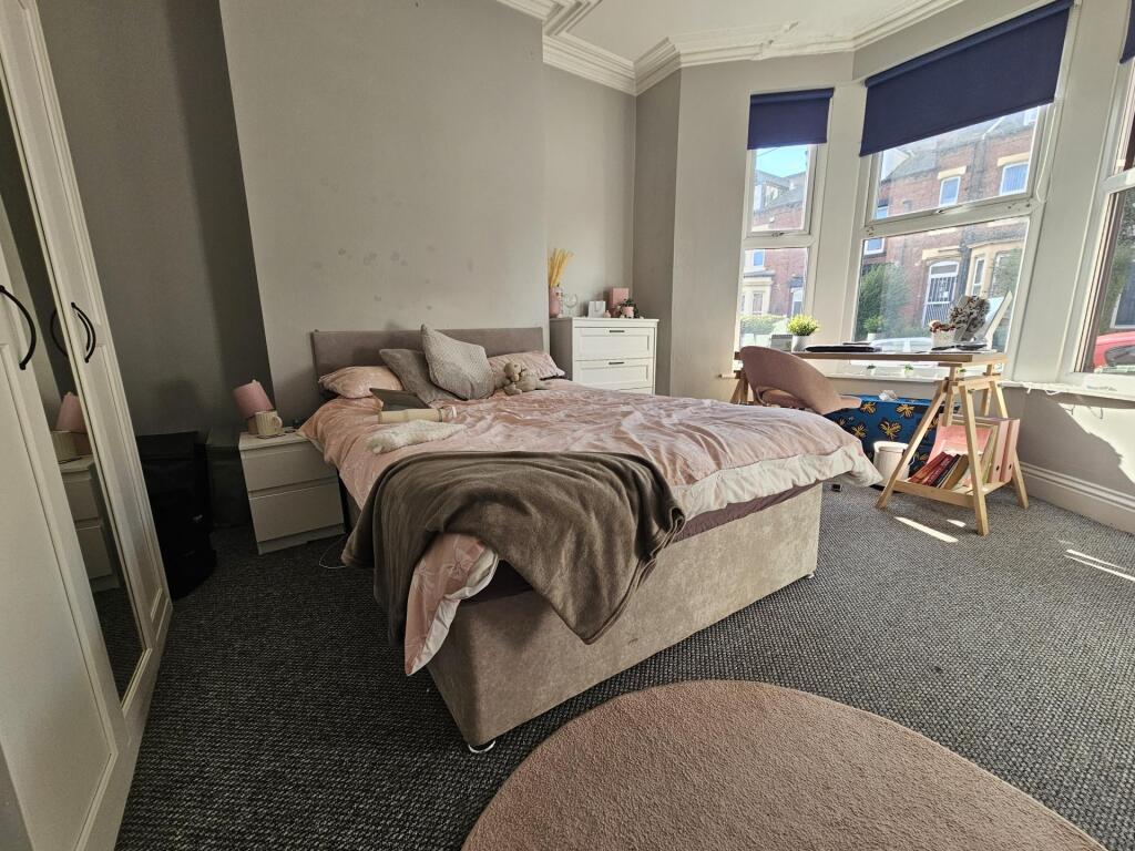 A cozy and stylish master bedroom featuring a c...