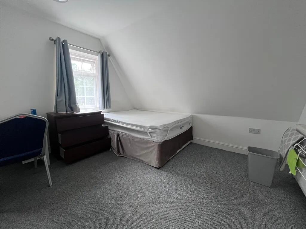 A cozy single bedroom featuring a comfortable b...