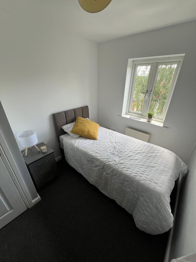 A neat, well-kept single bedroom featuring a co...
