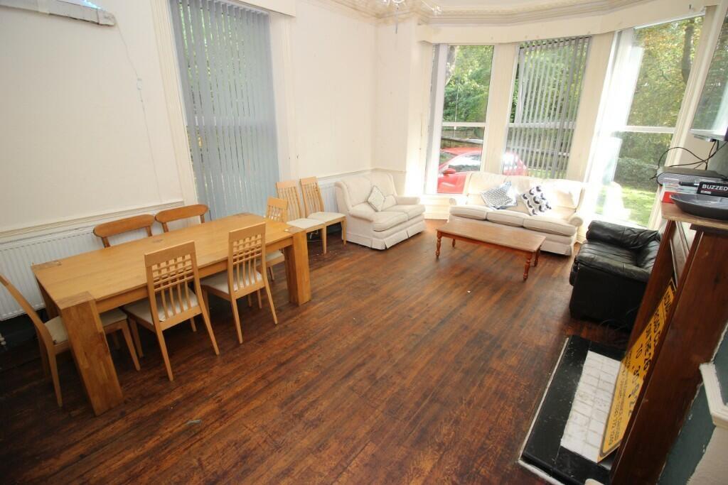 Bright and spacious living room featuring large...