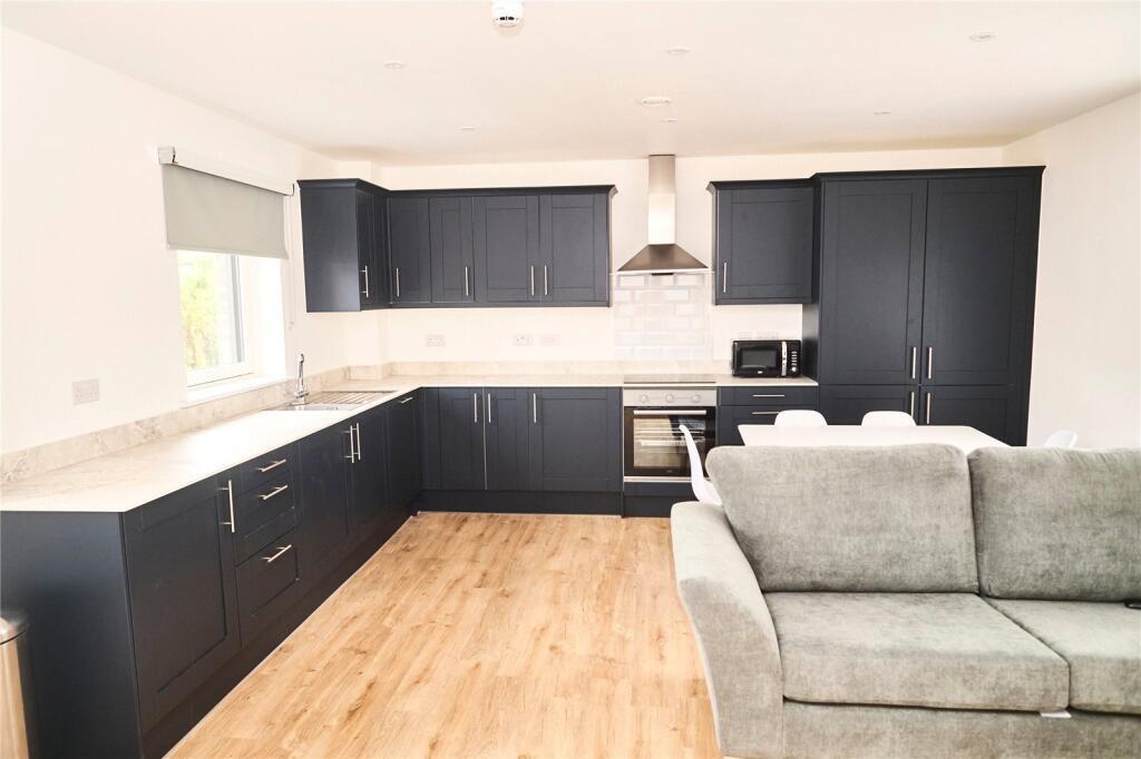Modern kitchen with sleek black cabinetry, ampl...