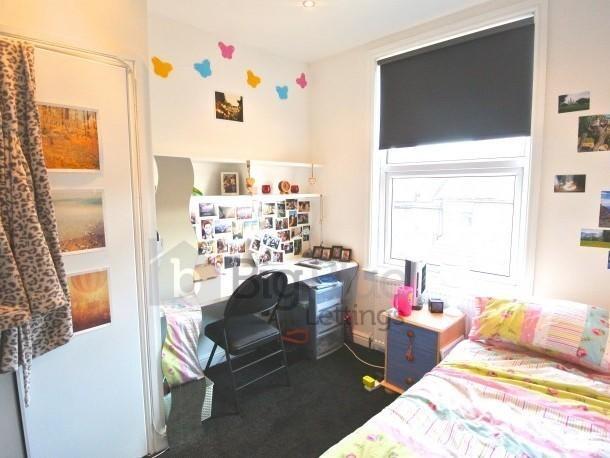 A cozy single bedroom featuring a comfortable b...