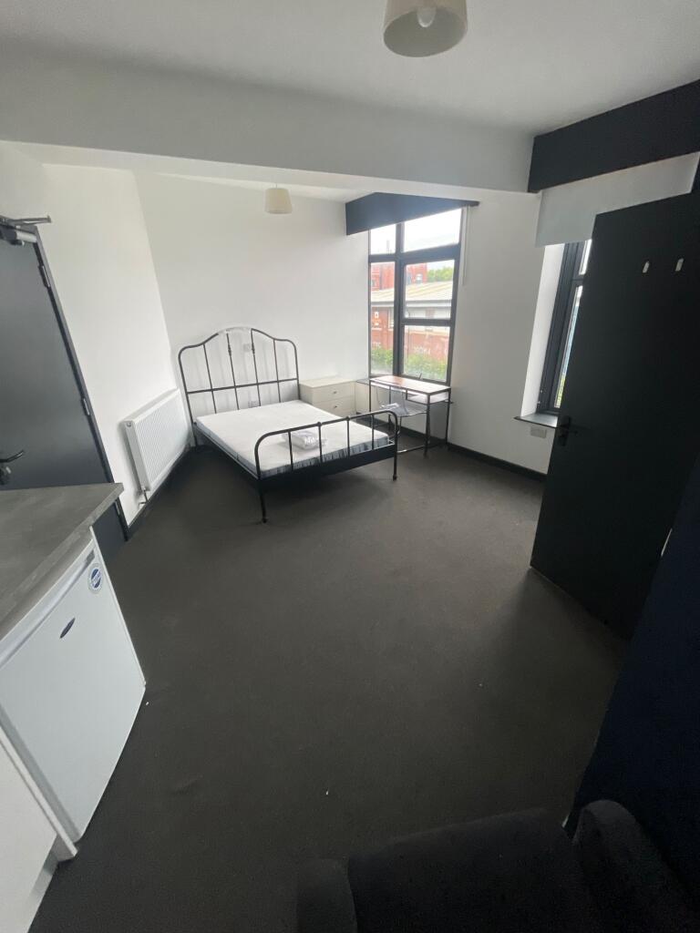 Bright double bedroom featuring large windows t...