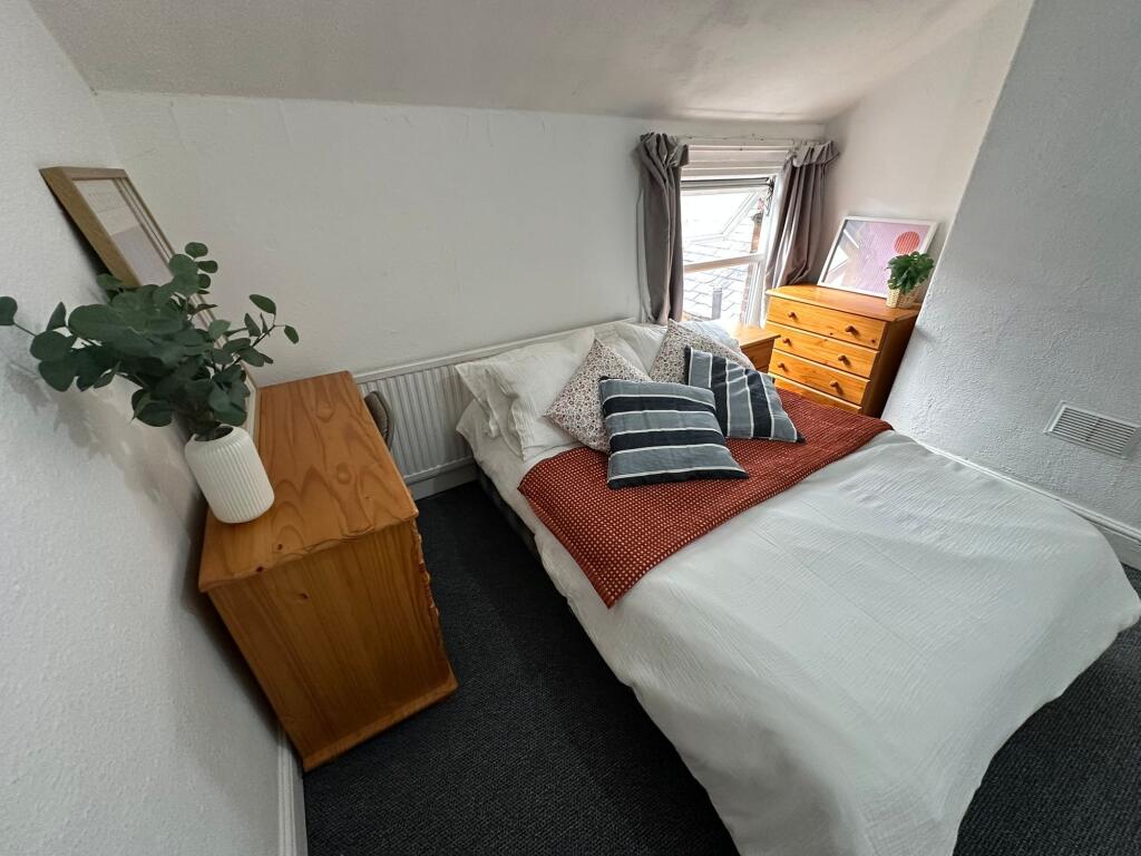 A cozy double bedroom featuring a comfortable b...