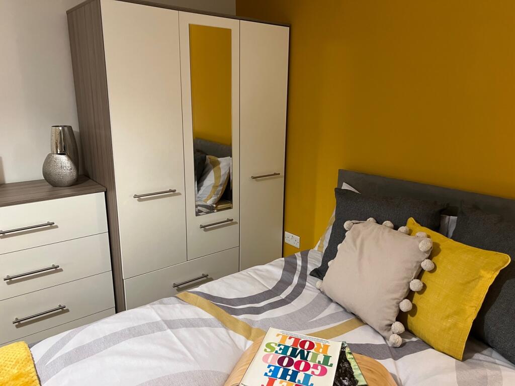 A bright and inviting double bedroom with styli...
