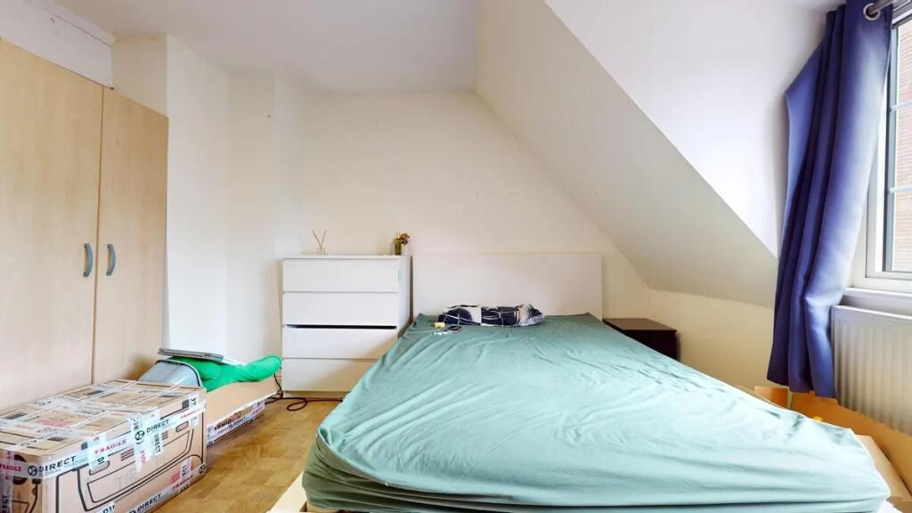 A cozy double bedroom featuring a large bed wit...