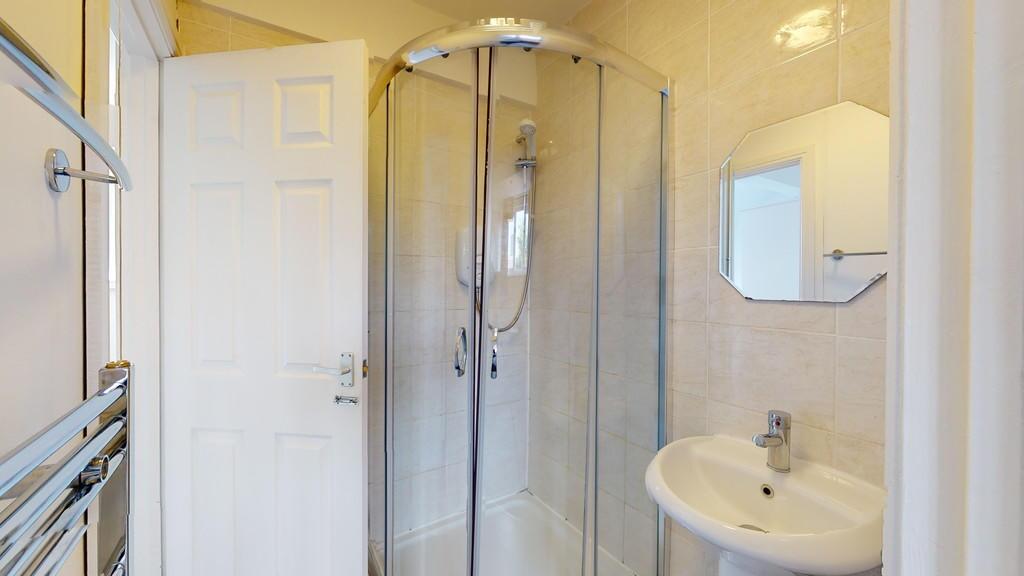 A clean, modern bathroom featuring a glass-encl...