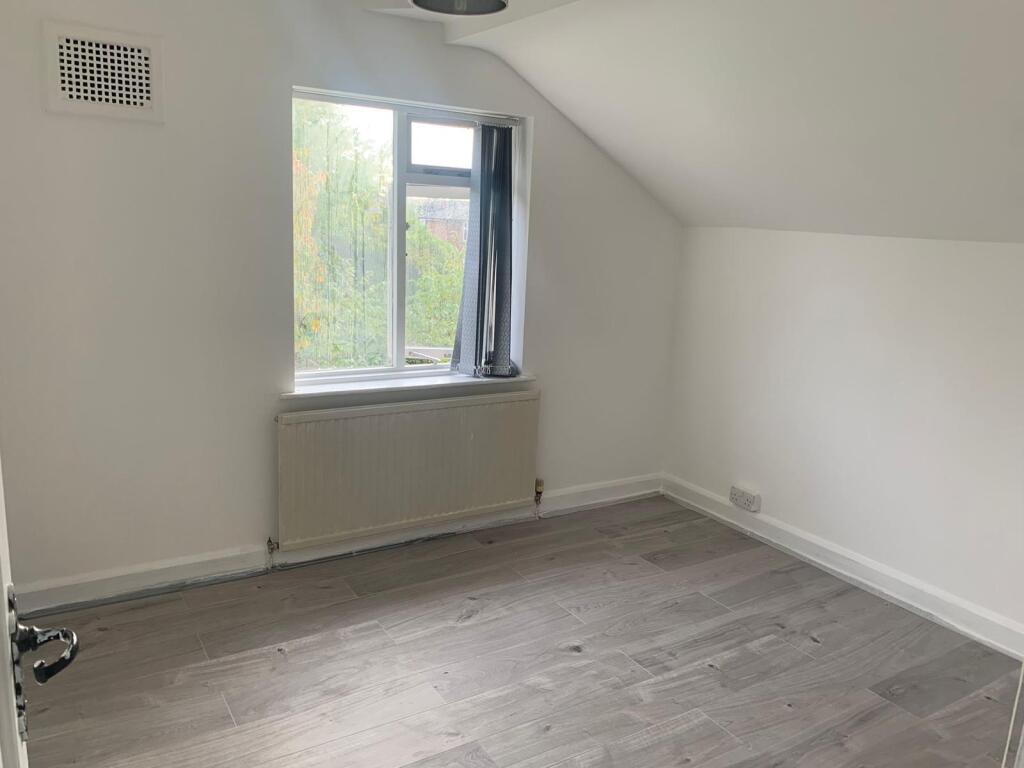 A bright and clean single bedroom featuring a l...