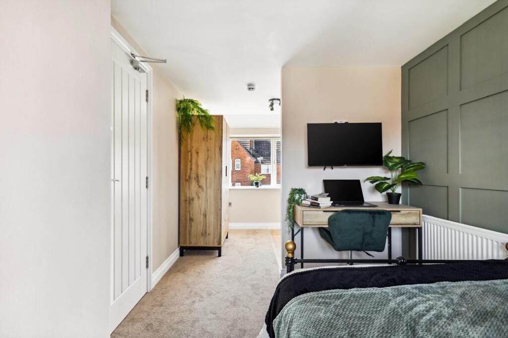 This stylish double bedroom features a comforta...